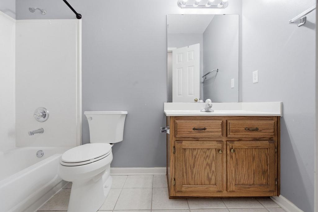 285 Great Falls Road Collierville, TN 38017 - Photo 21 of 29 White tile flooring, a single vanity with wood-finish cabinetry, a white countertop, and a white toilet