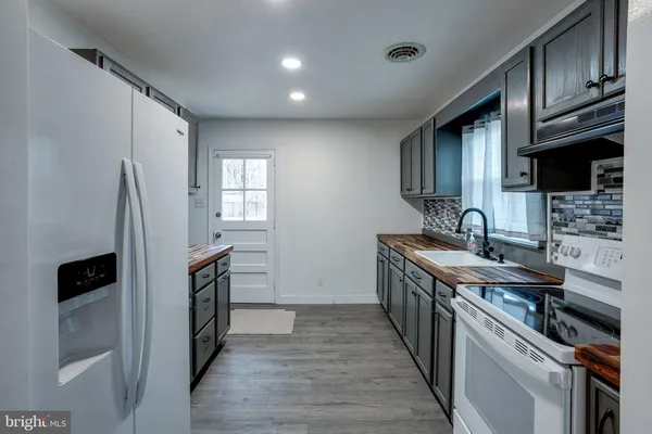 a kitchen with stainless steel appliances a sink stove and refrigerator