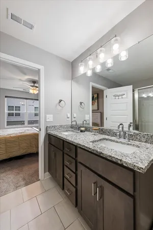a bathroom with a granite countertop sink a mirror and a bathtub