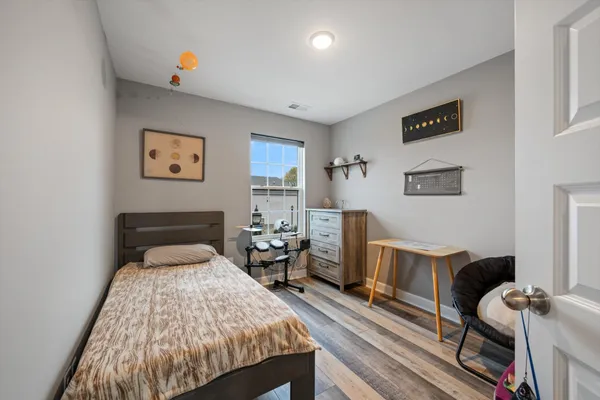 a bedroom with a bed and wooden floor