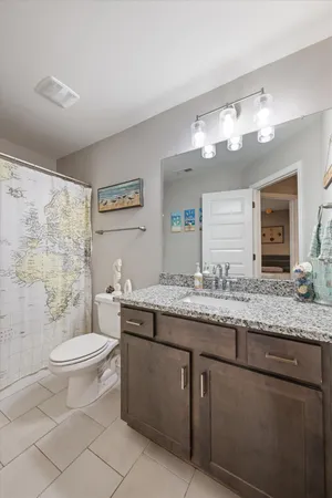 a bathroom with a granite countertop sink a toilet and a mirror