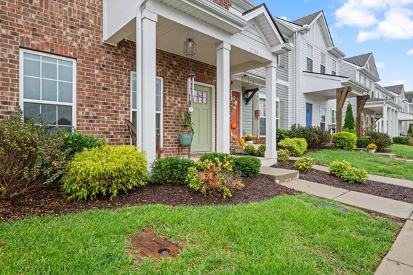 front view of a brick house with a yard