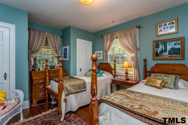 1103 Harvey Street Raleigh, NC 27608 - Photo 15 of 25 a bedroom with a bed and wooden floor