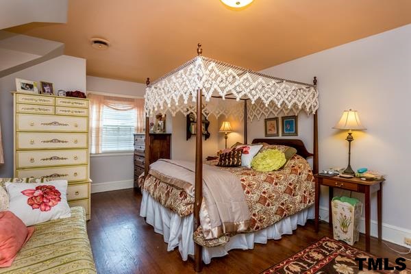 1103 Harvey Street Raleigh, NC 27608 - Photo 17 of 25 a bedroom with a bed and wooden floor