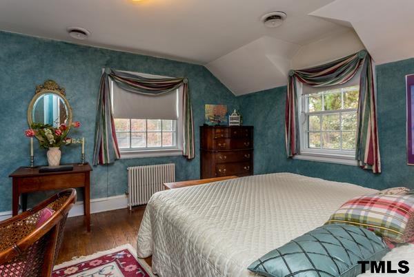 1103 Harvey Street Raleigh, NC 27608 - Photo 19 of 25 a bedroom with a bed and a dresser next to a window