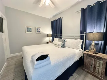 a bedroom with a bed and a flat tv screen on dresser