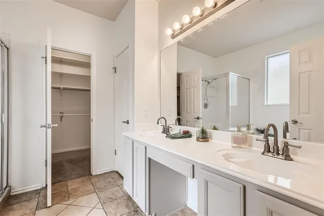 a view of an empty room with wooden floor and a ceiling fan