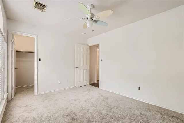 an empty room with a ceiling fan and a window