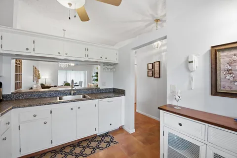 a spacious bathroom with a granite countertop sink and a mirror