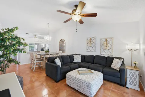 a living room with furniture kitchen view and a potted plant