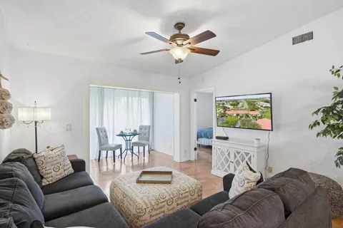 a living room with furniture and a view of kitchen