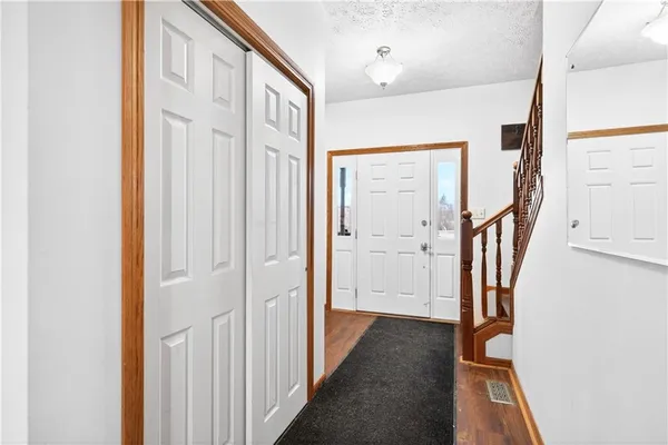 a view of a hallway with wooden floor and staircase