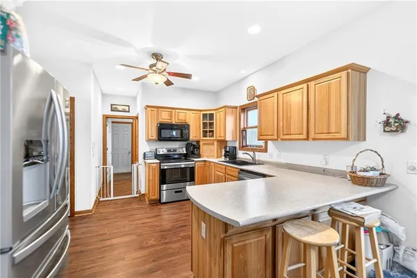 a kitchen with granite countertop a stove a sink and a refrigerator