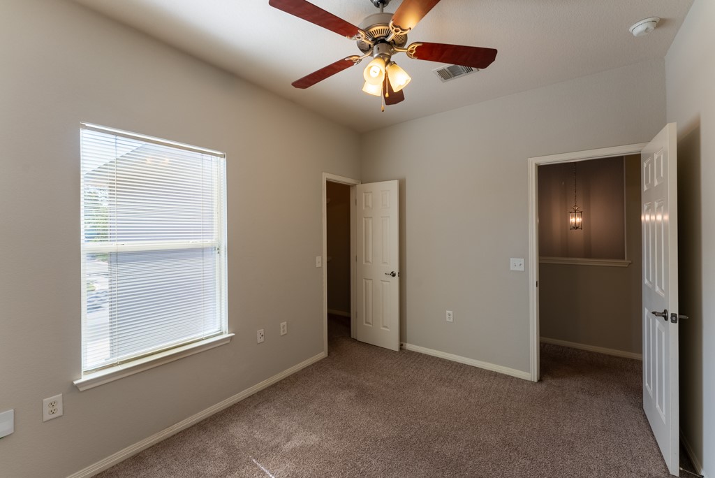 3000 Govalle Avenue, Unit B Austin, TX 78702 - Photo 19 of 26 Unfurnished bedroom featuring carpet, ceiling fan, and a spacious closet