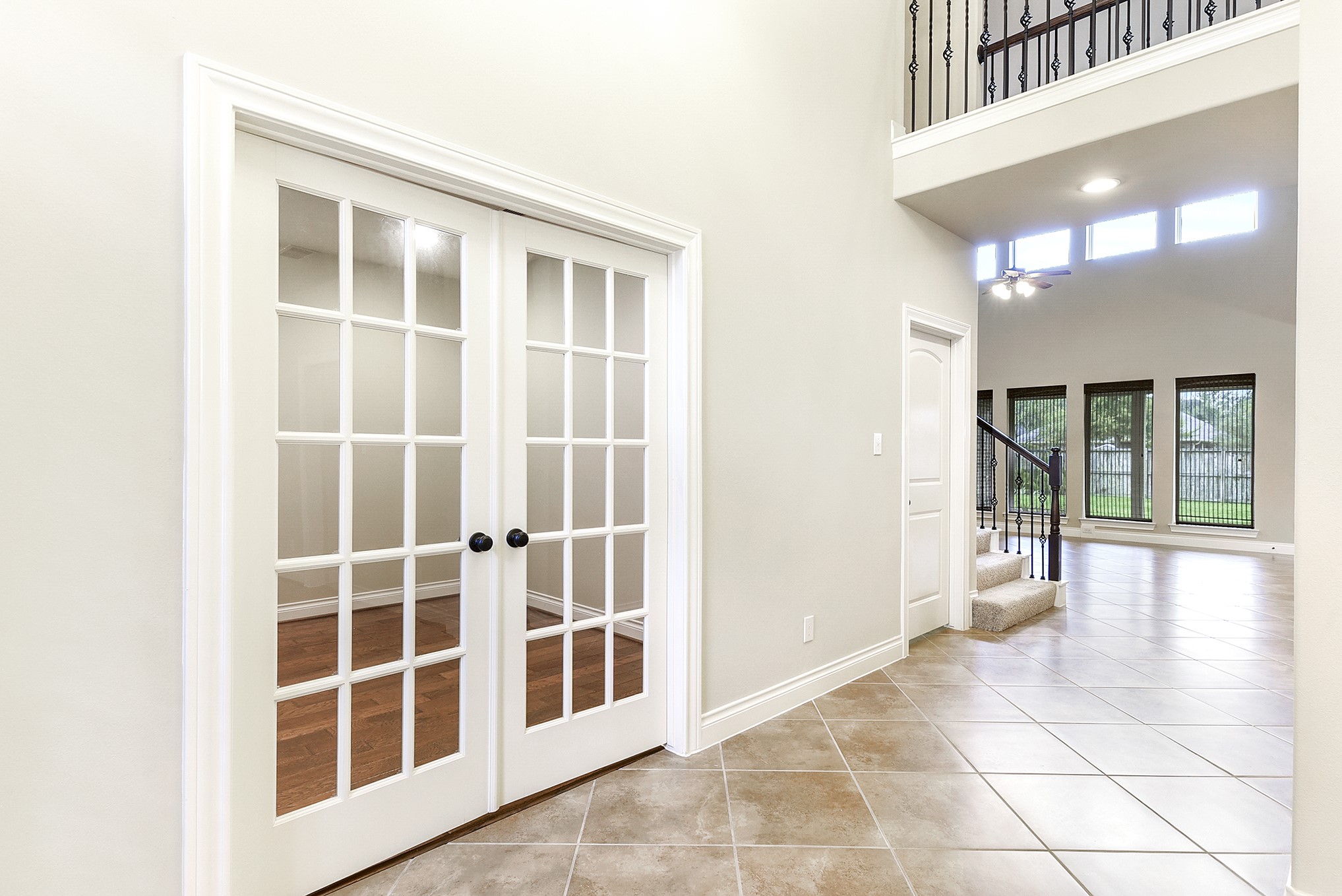 29023 Powder Ridge Drive Katy, TX 77494 - Photo 11 of 50 The welcoming foyer features tile flooring that flows seamlessly throughout the home’s wet areas. The wide entryway immediately creates a sense of space and sophistication. From this vantage point, the home office is located to the left and features elegant French doors, while offering beautiful sightlines into the spacious living room.