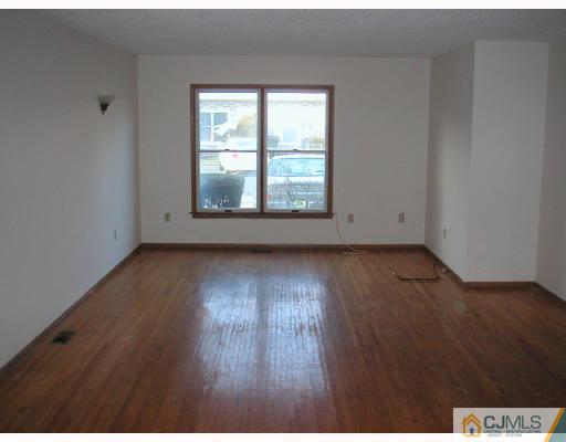 4705 Hana Road Edison, NJ 08817 - Photo 3 of 8 an empty room with wooden floor and windows