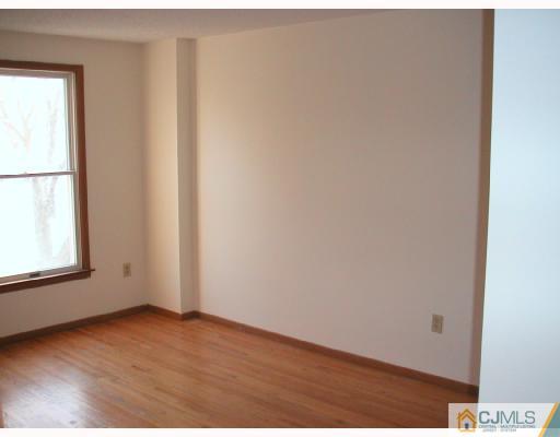 4705 Hana Road Edison, NJ 08817 - Photo 5 of 8 an empty room with wooden floor and windows