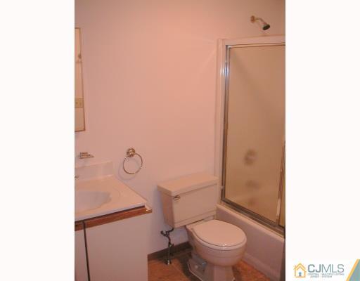 4705 Hana Road Edison, NJ 08817 - Photo 8 of 8 a bathroom with a granite countertop toilet and a sink