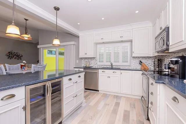 a kitchen with granite countertop a sink window and cabinets