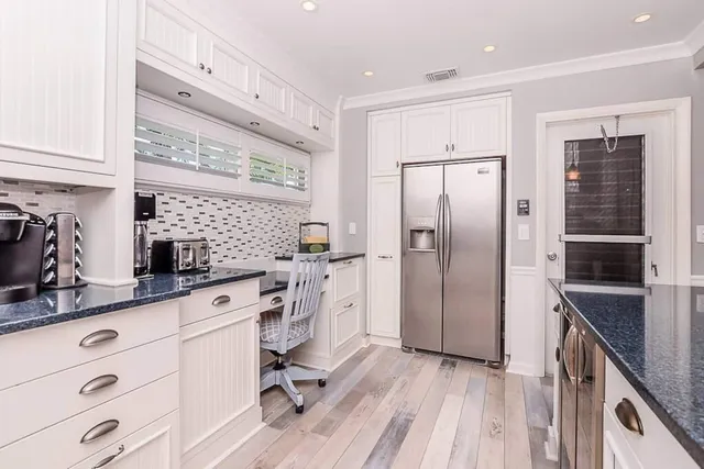 a kitchen with white cabinets and stainless steel appliances