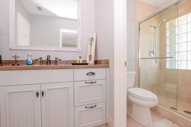 a white toilet sitting next to a shower