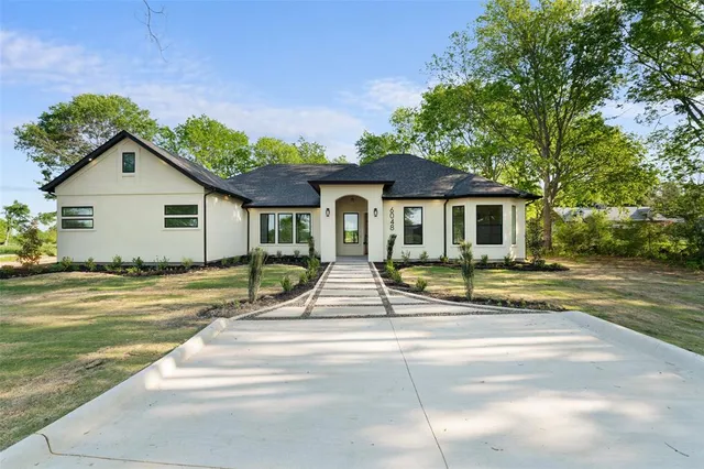 a view of a house with backyard and trees