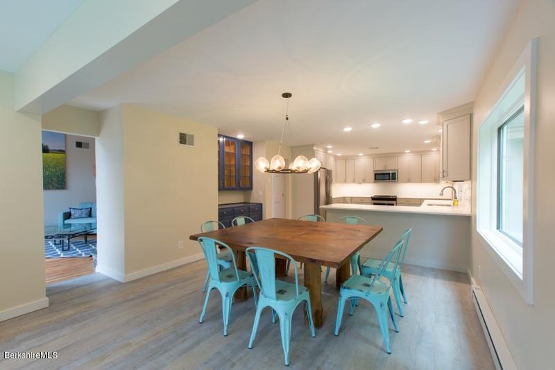 755 Tyringham Road Lee, MA 01238 - Photo 12 of 32 a dining room with a table chairs and kitchen view