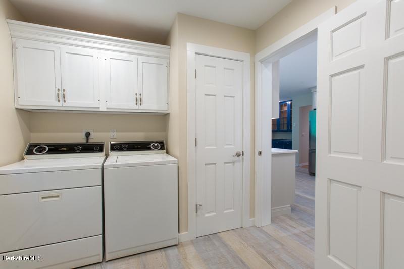 755 Tyringham Road Lee, MA 01238 - Photo 14 of 32 a view of washer and dryer with wooden cabinets