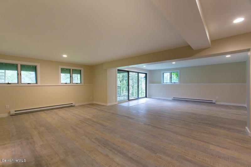 755 Tyringham Road Lee, MA 01238 - Photo 28 of 32 an empty room with wooden floor and windows