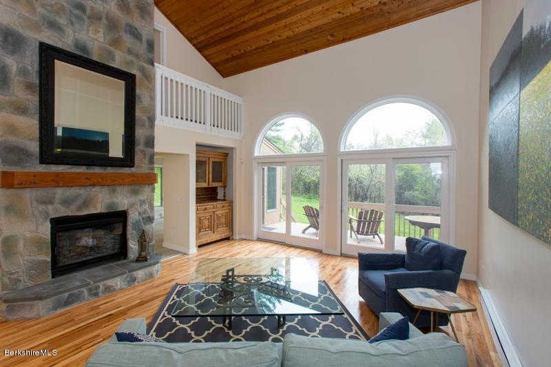 755 Tyringham Road Lee, MA 01238 - Photo 4 of 32 a living room with furniture a fireplace and a large window