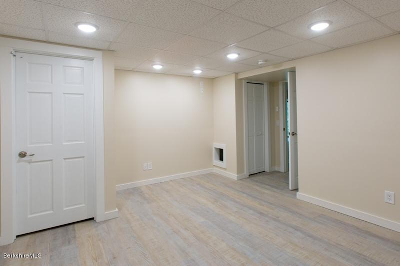 755 Tyringham Road Lee, MA 01238 - Photo 31 of 32 an empty room with wooden floor and windows