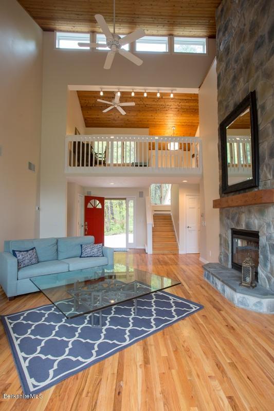 755 Tyringham Road Lee, MA 01238 - Photo 6 of 32 a living room with a fireplace and a open kitchen view