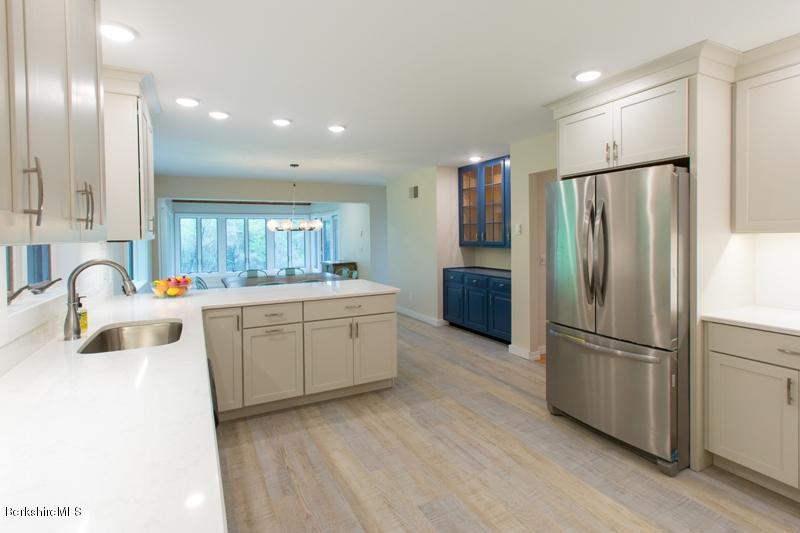 755 Tyringham Road Lee, MA 01238 - Photo 8 of 32 a kitchen with a refrigerator sink and cabinets