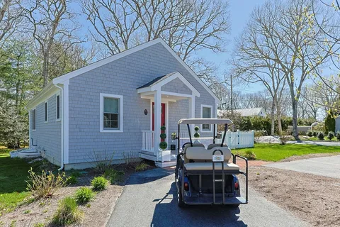 a view of a house with a patio and a yard