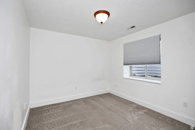 2912 South 1080th Street West Logan, UT 84321 - Photo 21 of 43 Room featuring neutral-toned carpet, white walls, and a window with a cellular shade