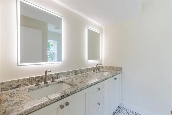 a bathroom with a granite countertop sink and a mirror