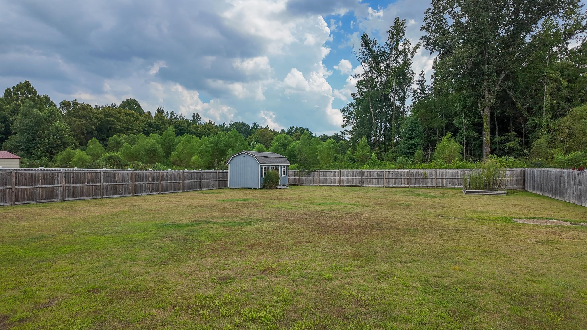 5217 Nail Road Olive Branch, MS 38654 - Photo 30 of 35 Fenced backyard featuring a storage unit and a view of trees