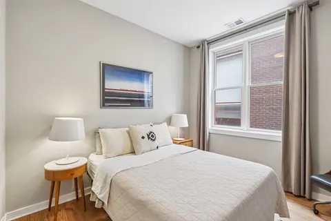 a bedroom with a bed and a lamp next to a window