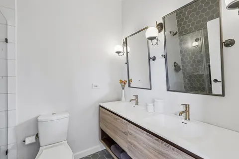 a bathroom with a sink a toilet and shower