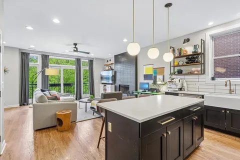 a large kitchen with kitchen island a large island in the center and a large window