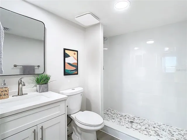 a bathroom with a sink a toilet and shower