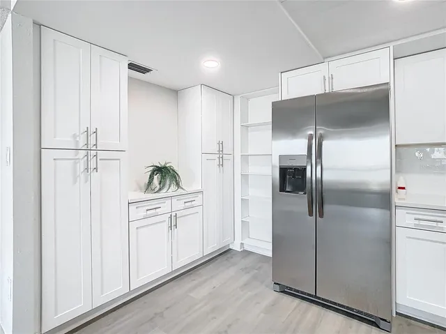 a kitchen with white cabinets and stainless steel appliances