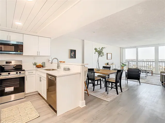 a living room with furniture a dining table and chairs with wooden floor