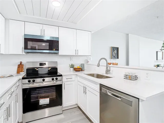 a kitchen with stainless steel appliances granite countertop a sink a stove a microwave and cabinets