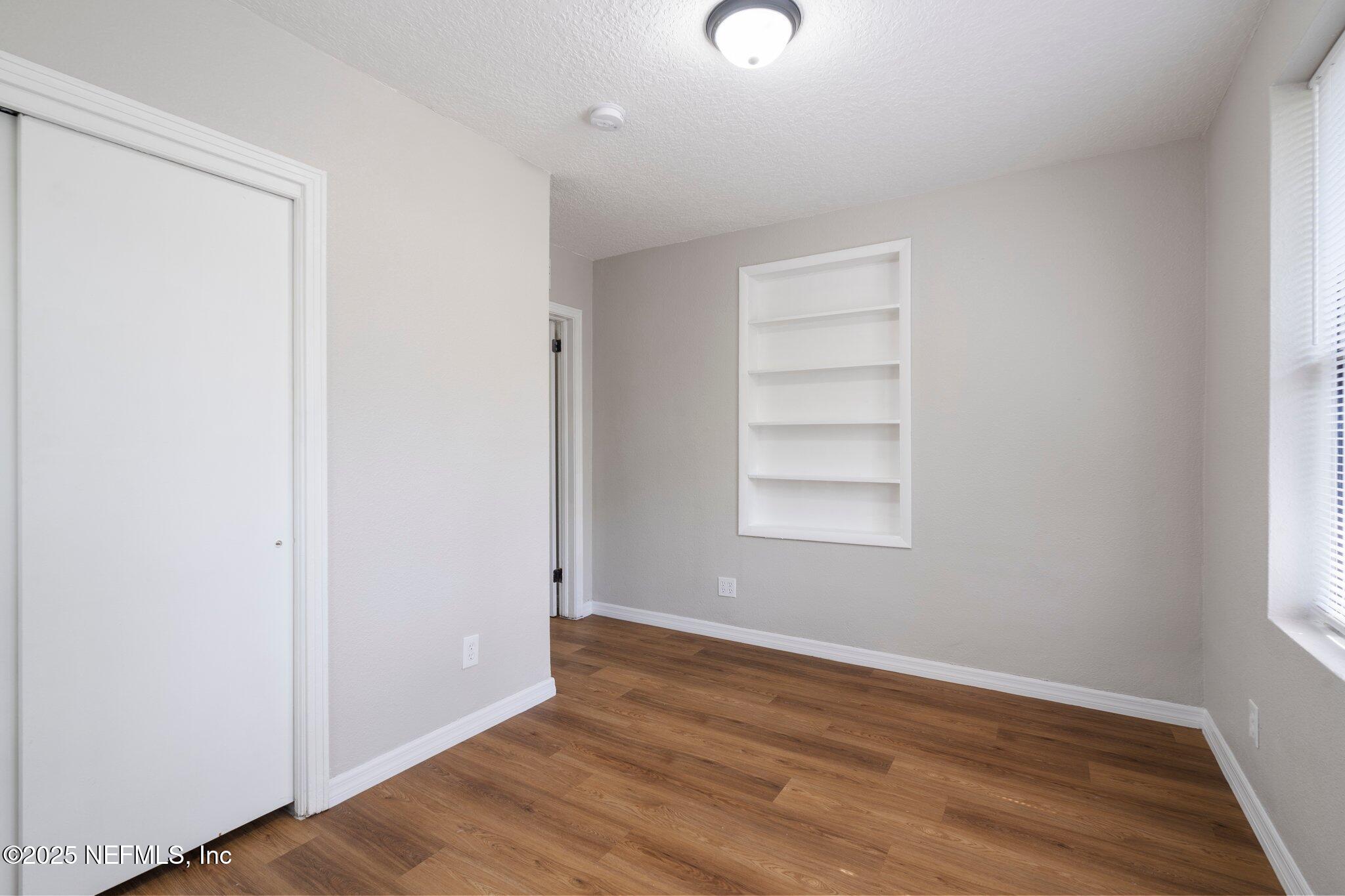 2838 Rainbow Road Jacksonville, FL 32217 - Photo 28 of 35 an empty room with wooden floor and window