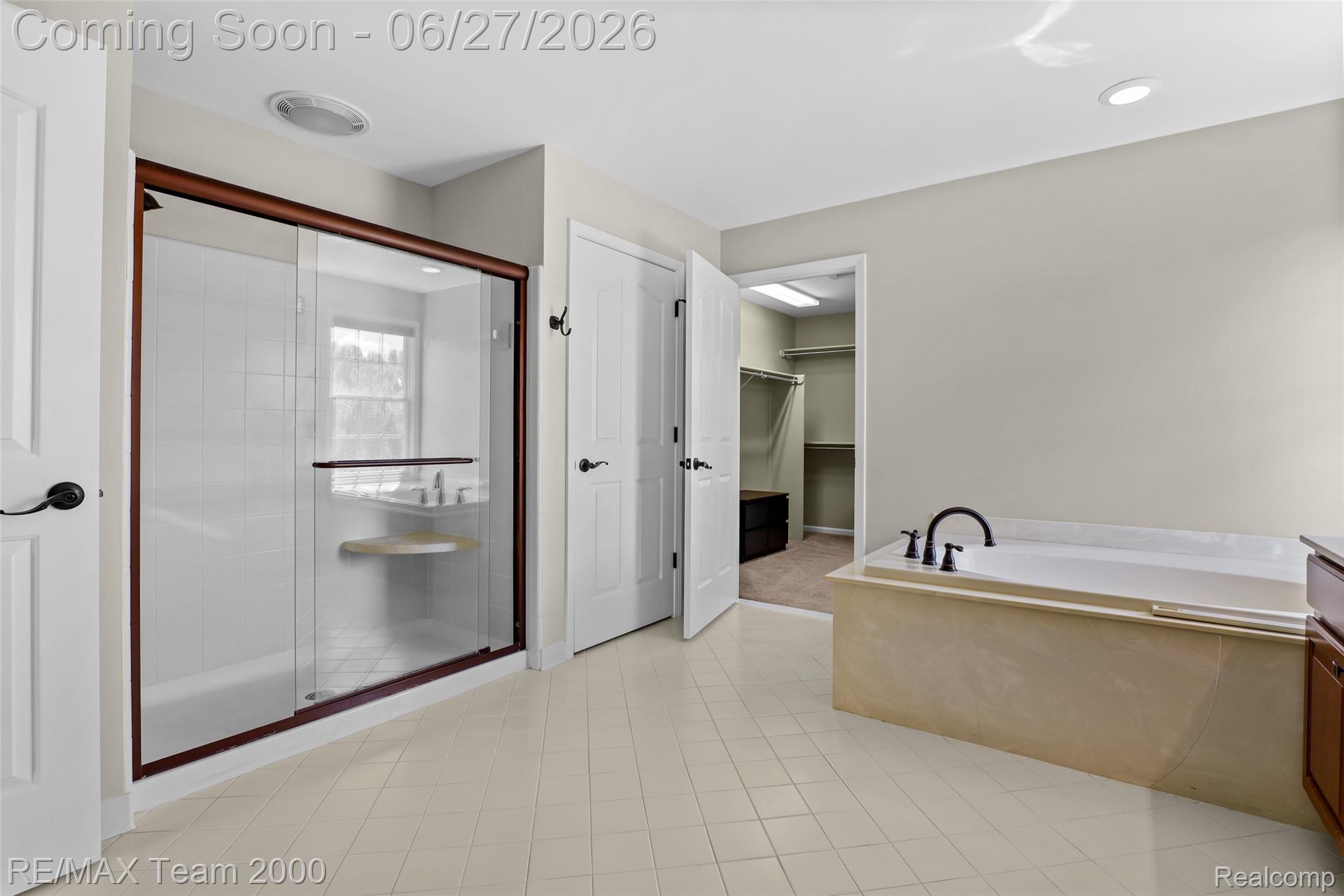 1248 Lasalle Road Canton, MI 48187 - Photo 57 of 67 Bathroom featuring a built-in soaking tub with a matte black faucet, a glass-enclosed shower with a built-in seat, light-toned floor tiling, and a recessed ceiling light