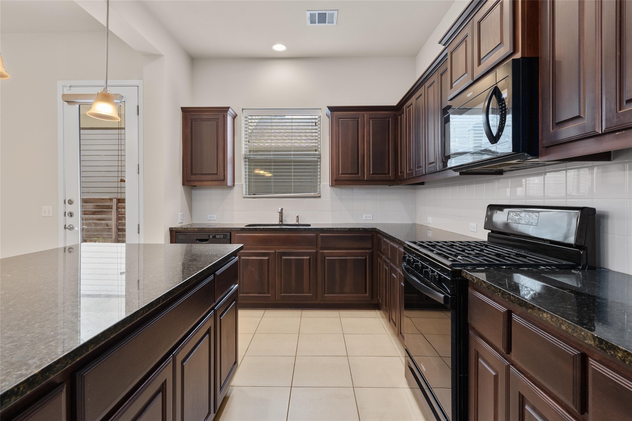 6907 Idea Road Austin, TX 78741 - Photo 7 of 36 a kitchen with stainless steel appliances a sink dishwasher a stove top oven a refrigerator and cabinets