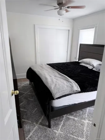 a bedroom with a bed window and a ceiling fan