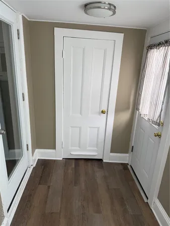 an empty room with wooden floor and window