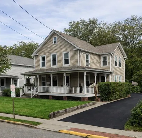 a front view of a house with a yard and trees